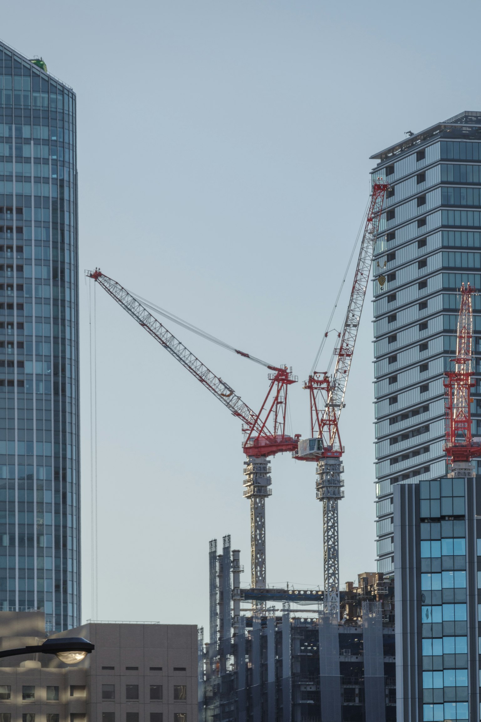Gambar crane konstruksi di antara gedung tinggi