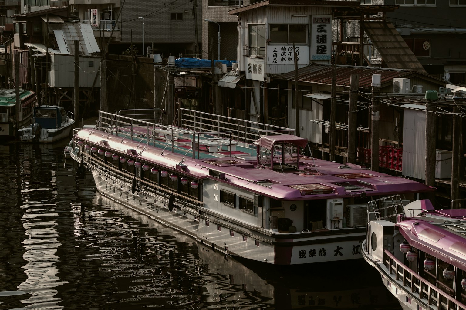 水面上停靠的紫色船只与周围建筑的倒影