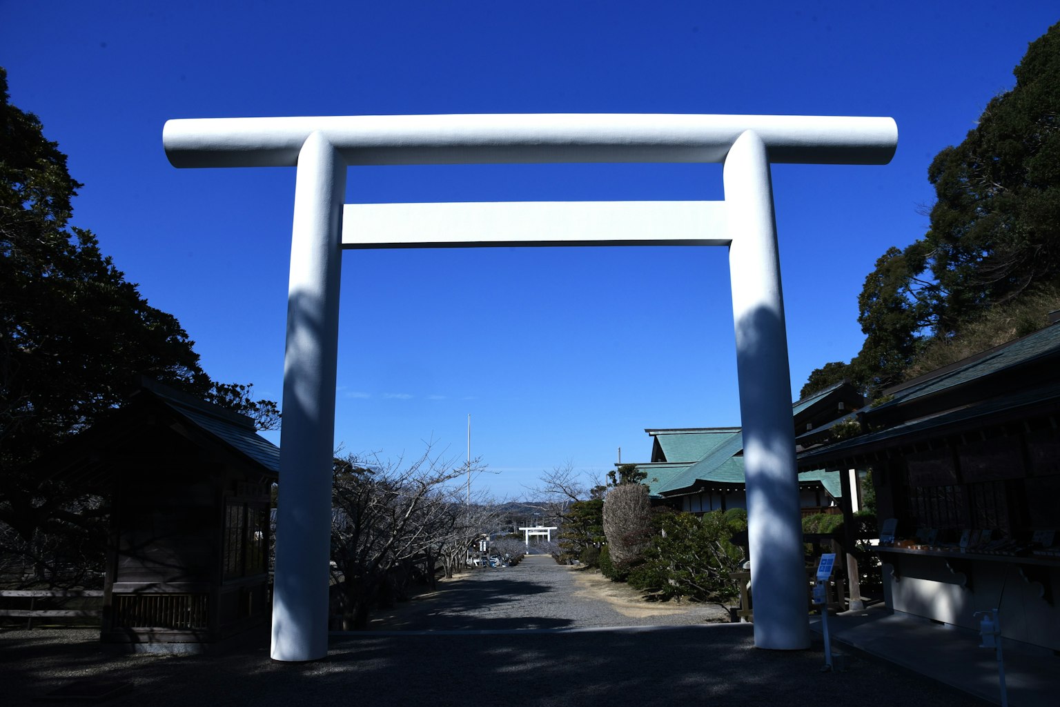 白色鸟居在晴朗蓝天下的神社