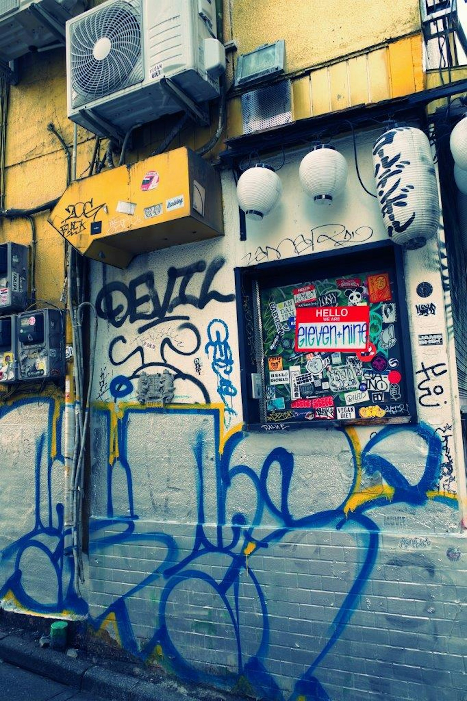 Extérieur d'un bâtiment avec de l'art de rue et des graffitis sur des murs jaunes