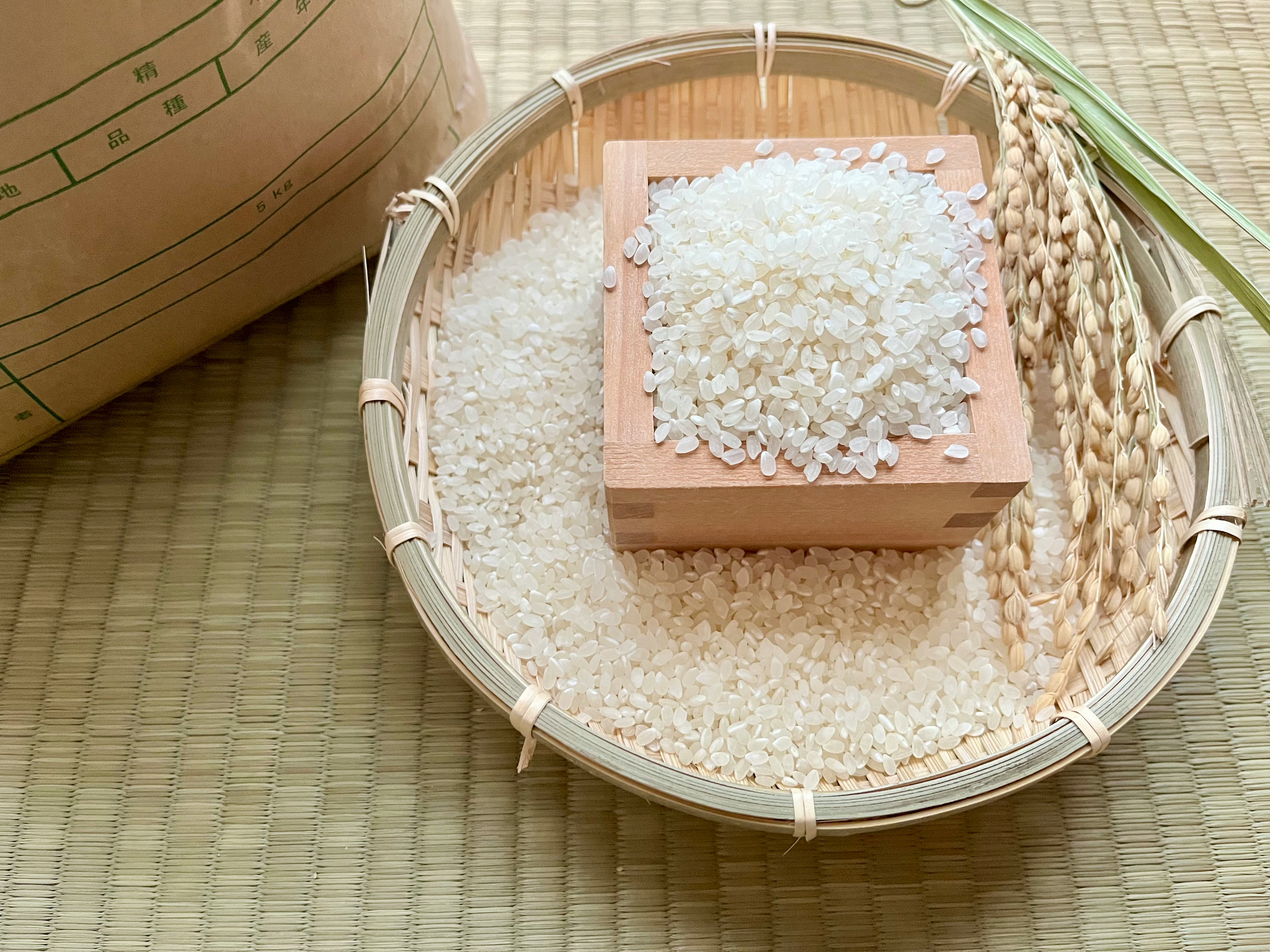 米粒と米袋のある竹かごの米収納