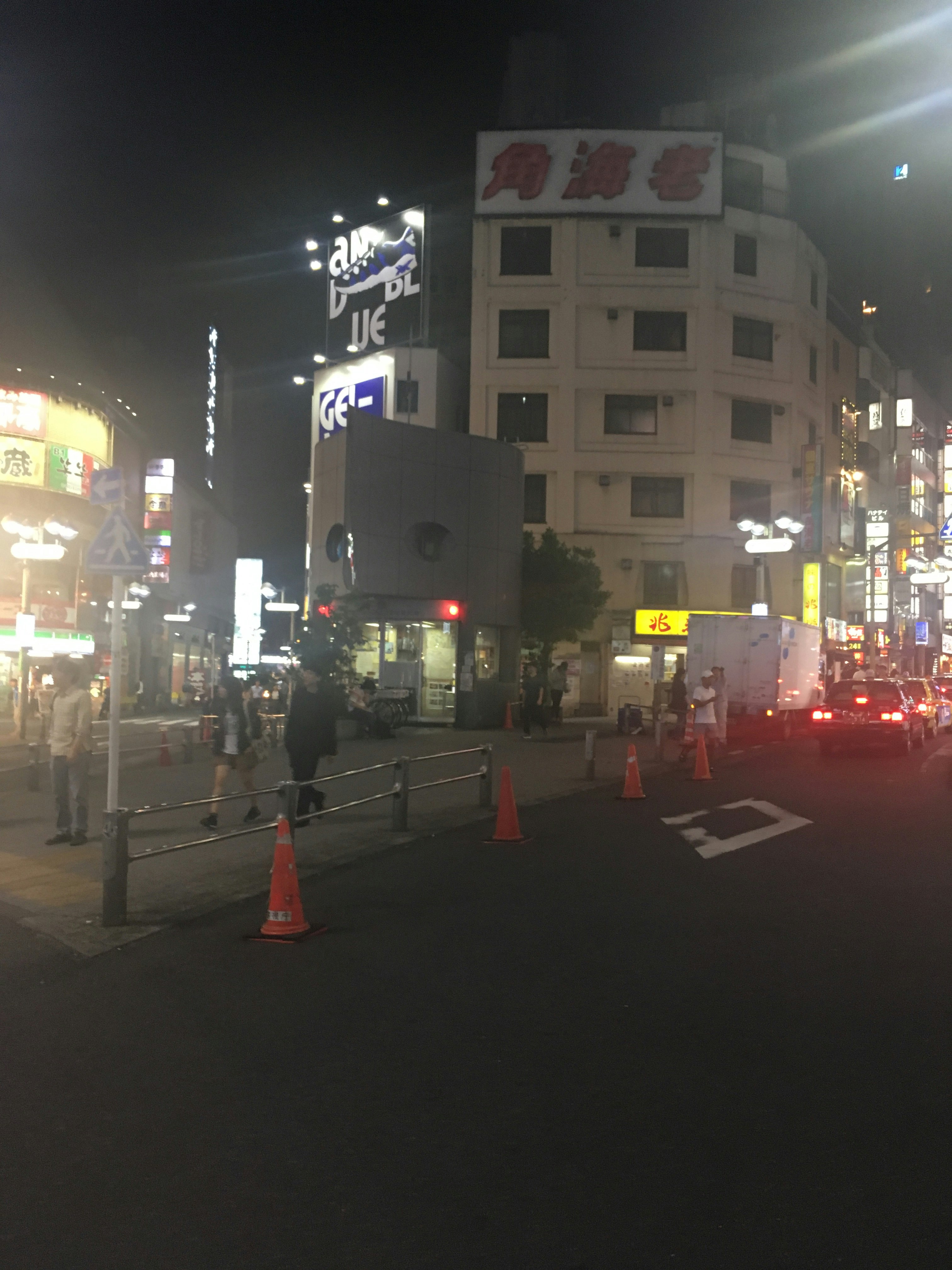 夜の交差点で信号とオレンジコーンが並ぶ街並み