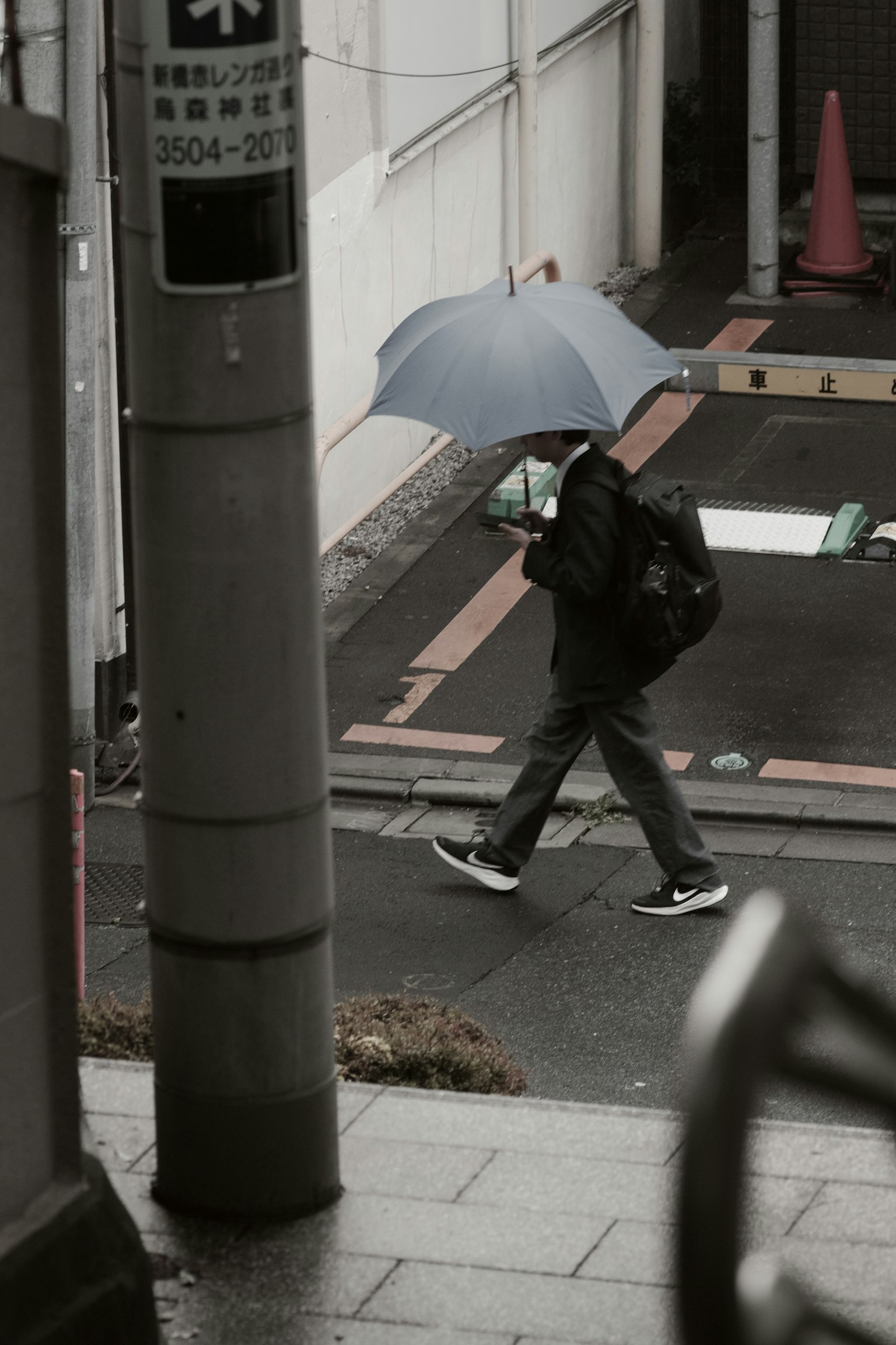 Una persona che cammina con un ombrello in un contesto urbano
