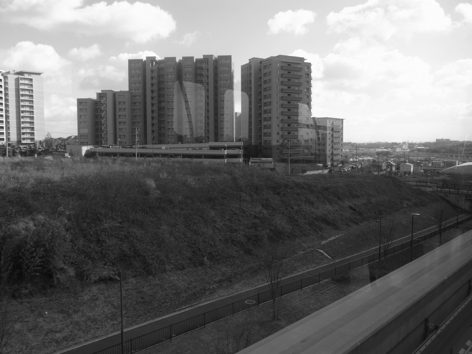 Black and white image of urban skyscrapers and a road