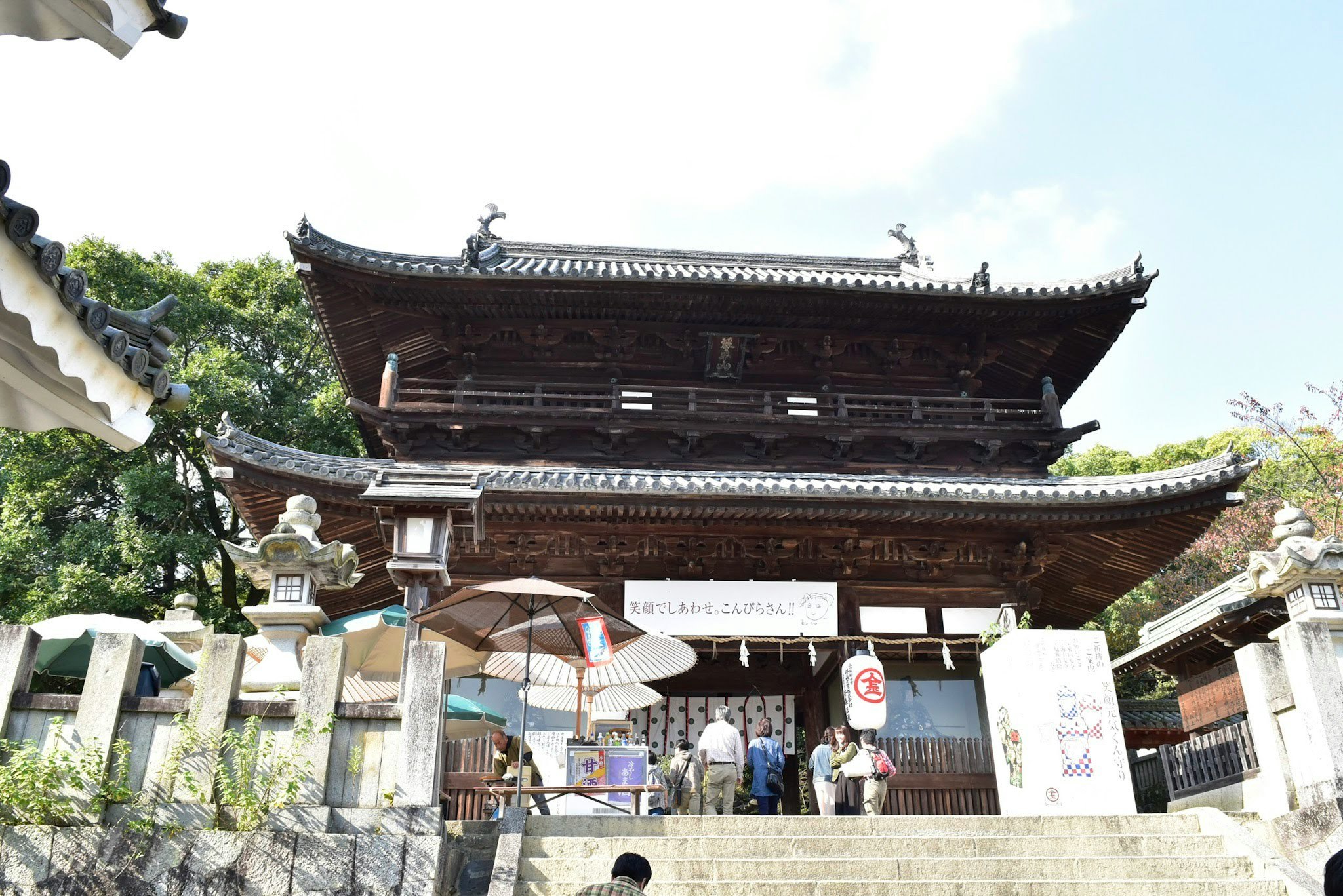 寺院の山門前で人が行き交う風景