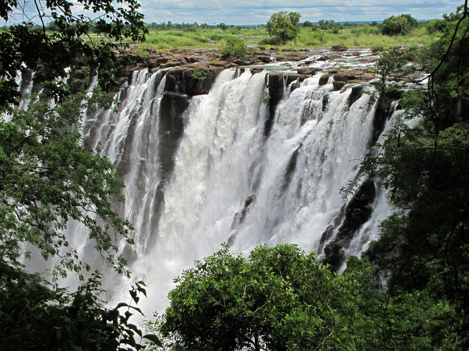 Una impresionante cascada que cae en un paisaje verde