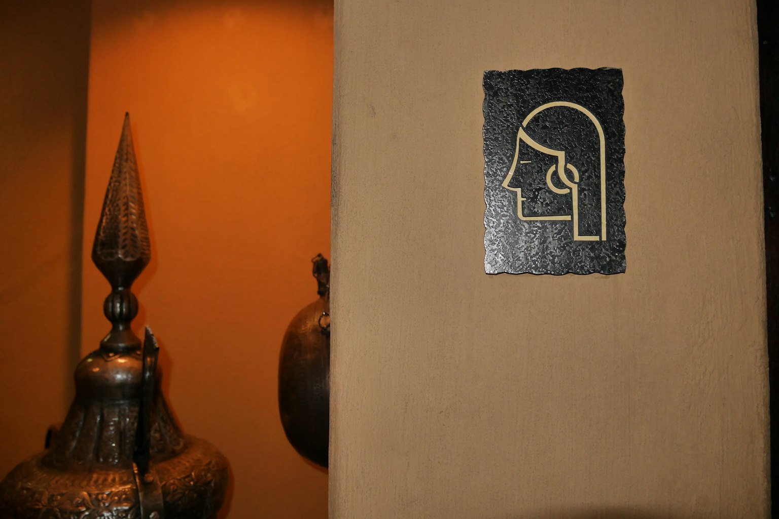 Icône du profil d'une femme sur un mur avec des artefacts métalliques décoratifs