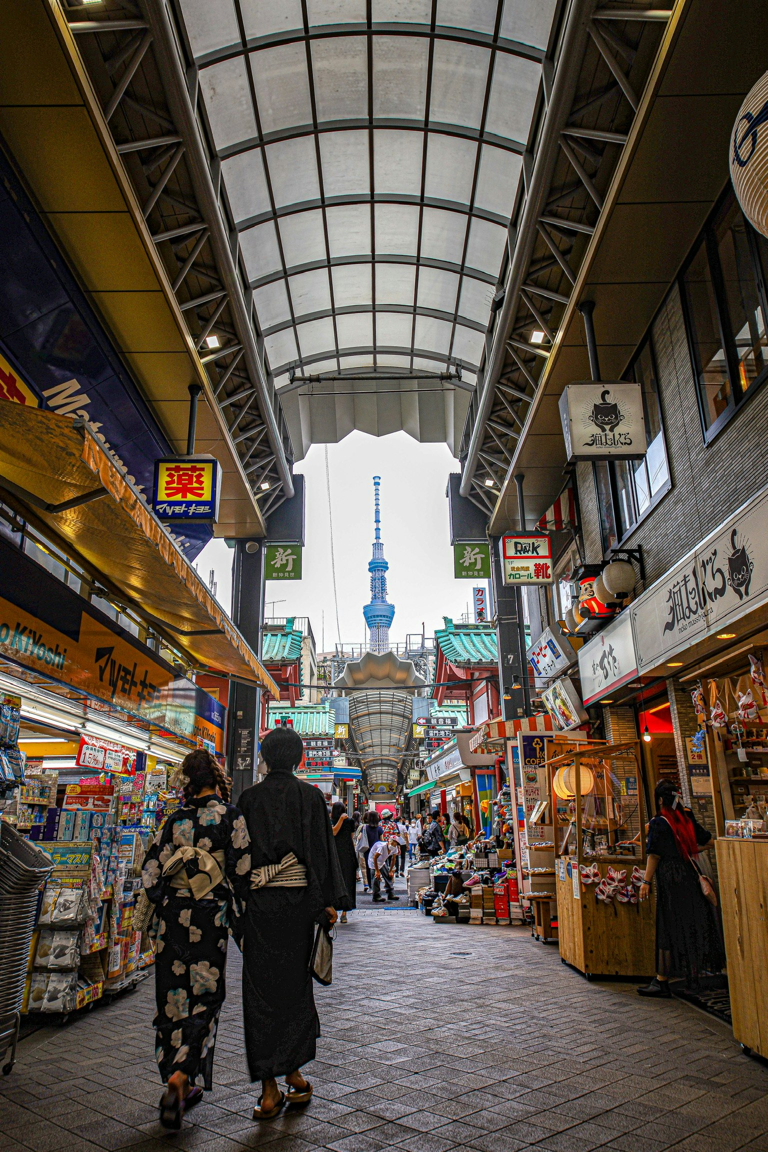 アーケードの商店街を歩く人々のある通りの風景