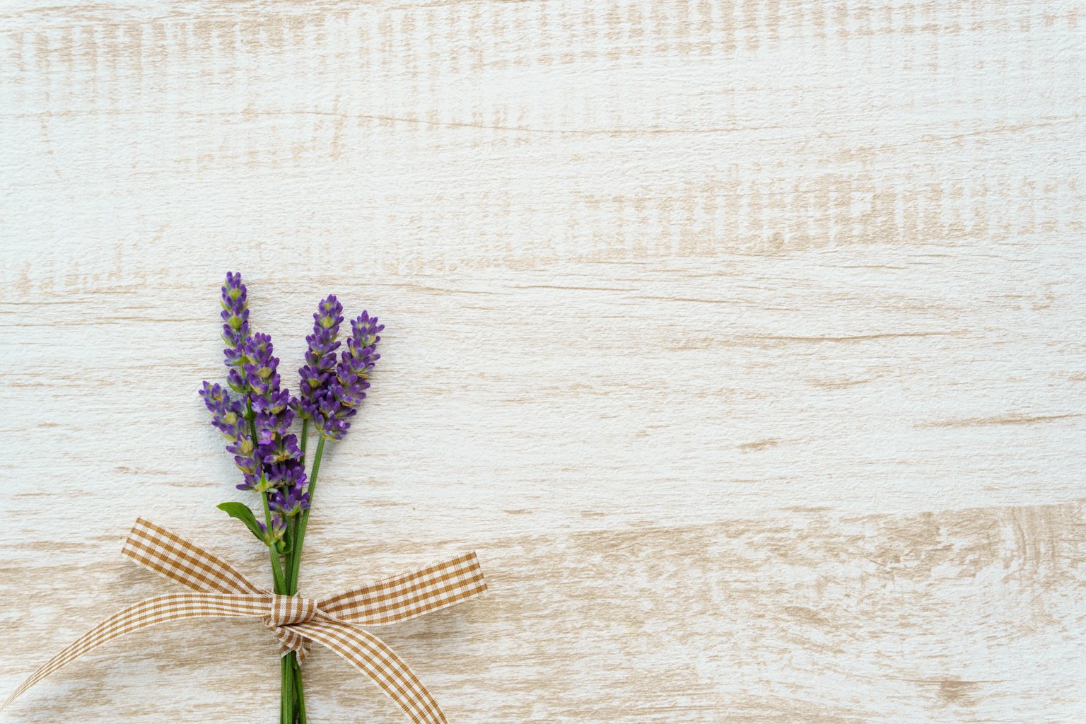 Fleur de lavande avec un ruban sur fond en bois clair