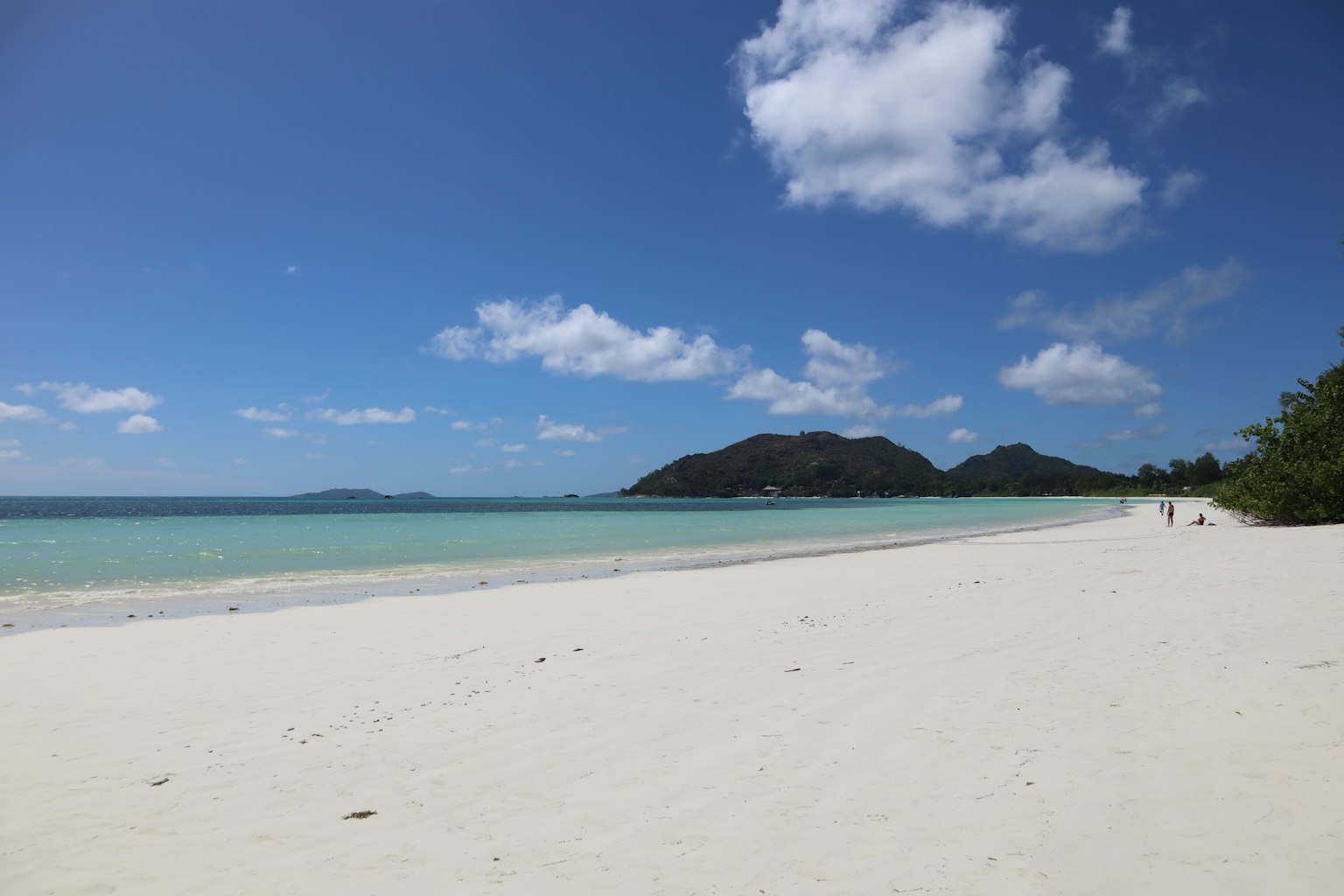 A beautiful beach scene with white sand and blue ocean