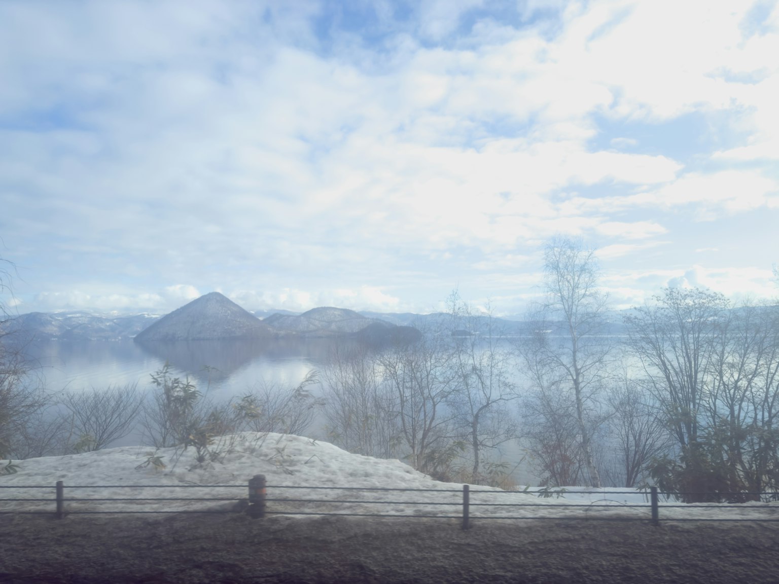 美麗的風景，山脈籠罩在霧中，地面覆蓋著雪