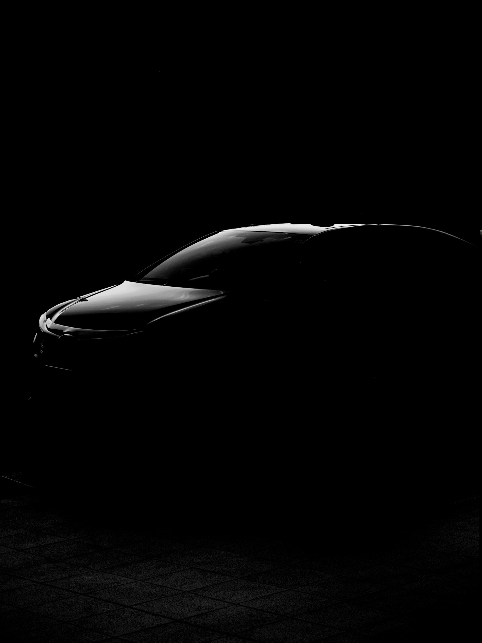 Silhouette di un'auto nera illuminata in bassa luce