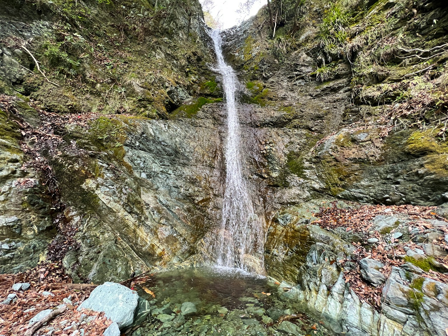 A beautiful waterfall cascading between rocks surrounded by lush greenery in a natural landscape
