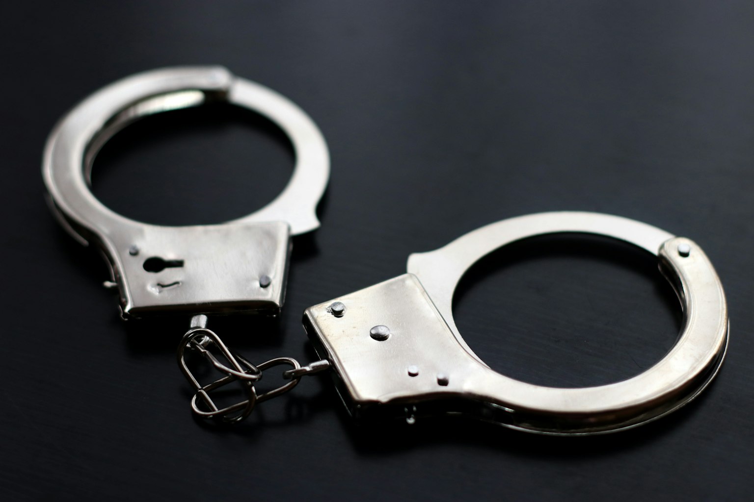 Handcuff logam diletakkan di latar belakang hitam