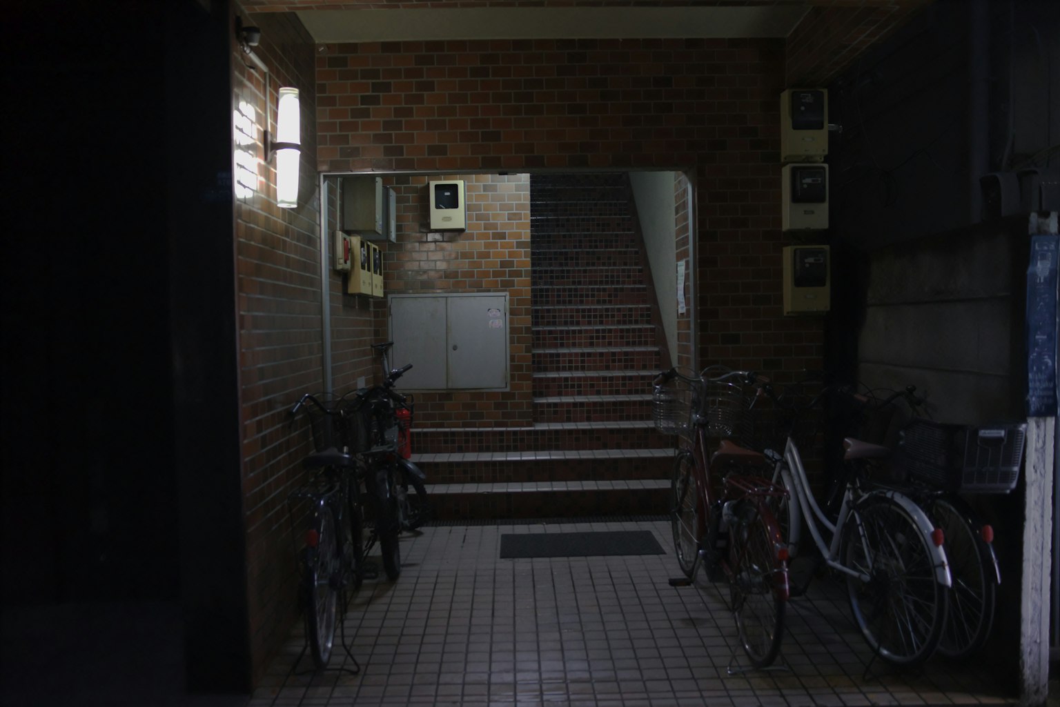 Pintu masuk tangga di lorong gelap dengan sepeda terparkir