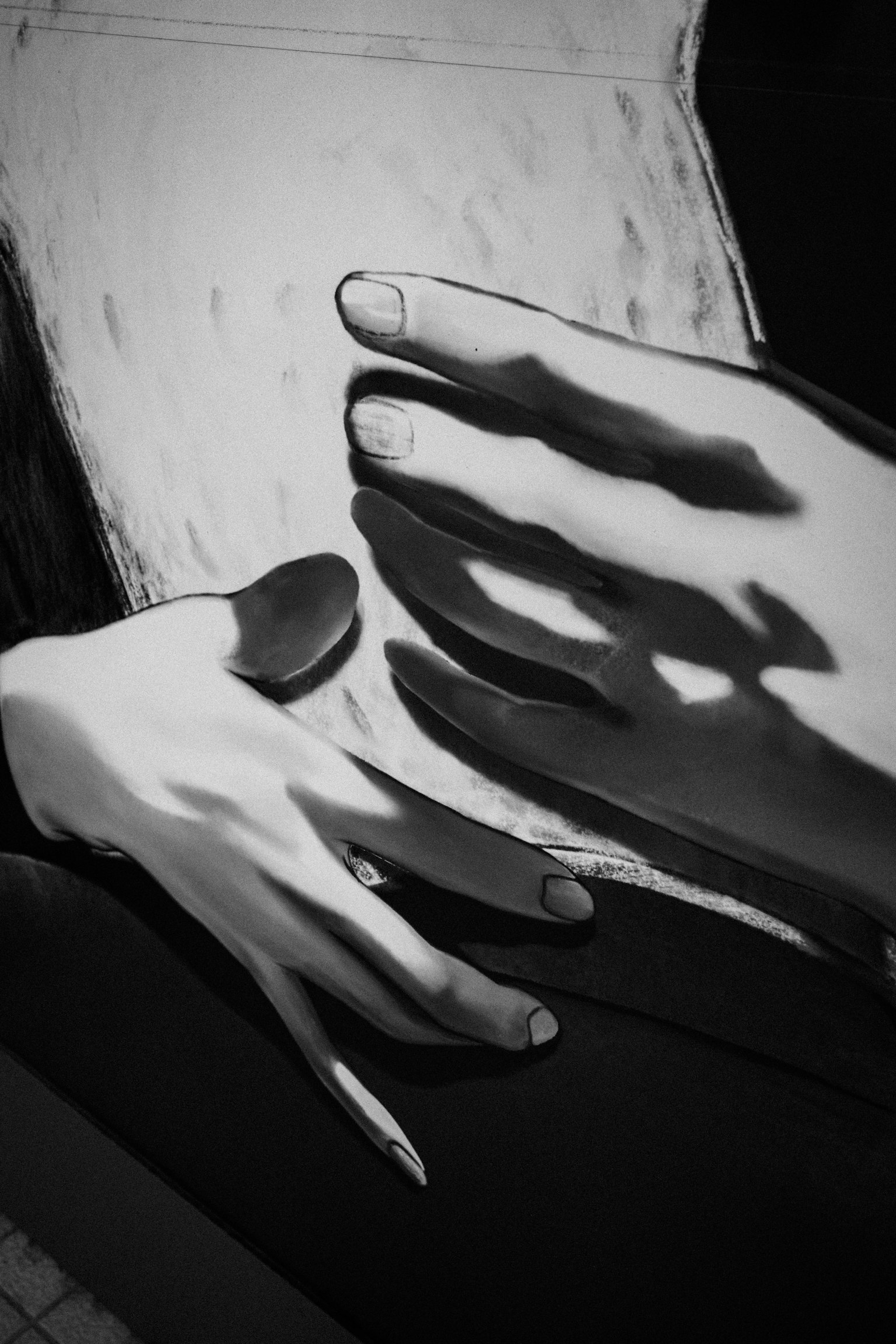 Künstlerische Darstellung von Händen und Schatten in Schwarzweiß