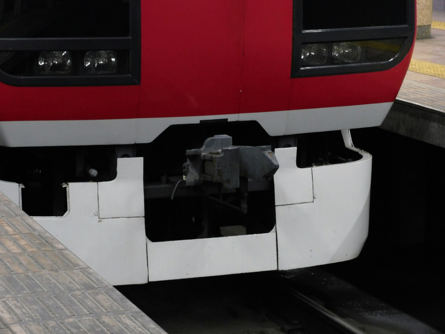 Close-up of a red train's front and platform connection