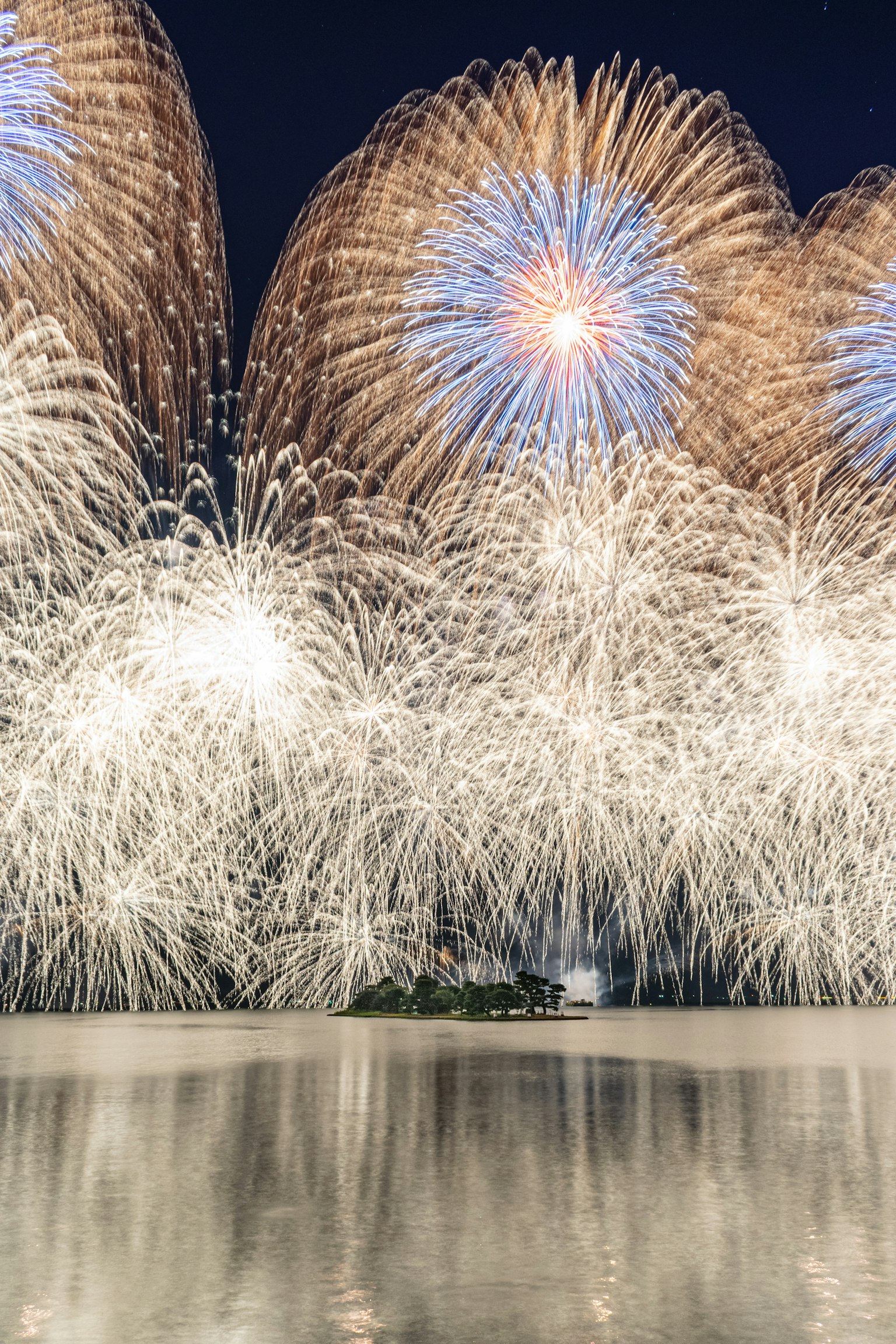 Beautiful fireworks illuminating the night sky reflected on the water