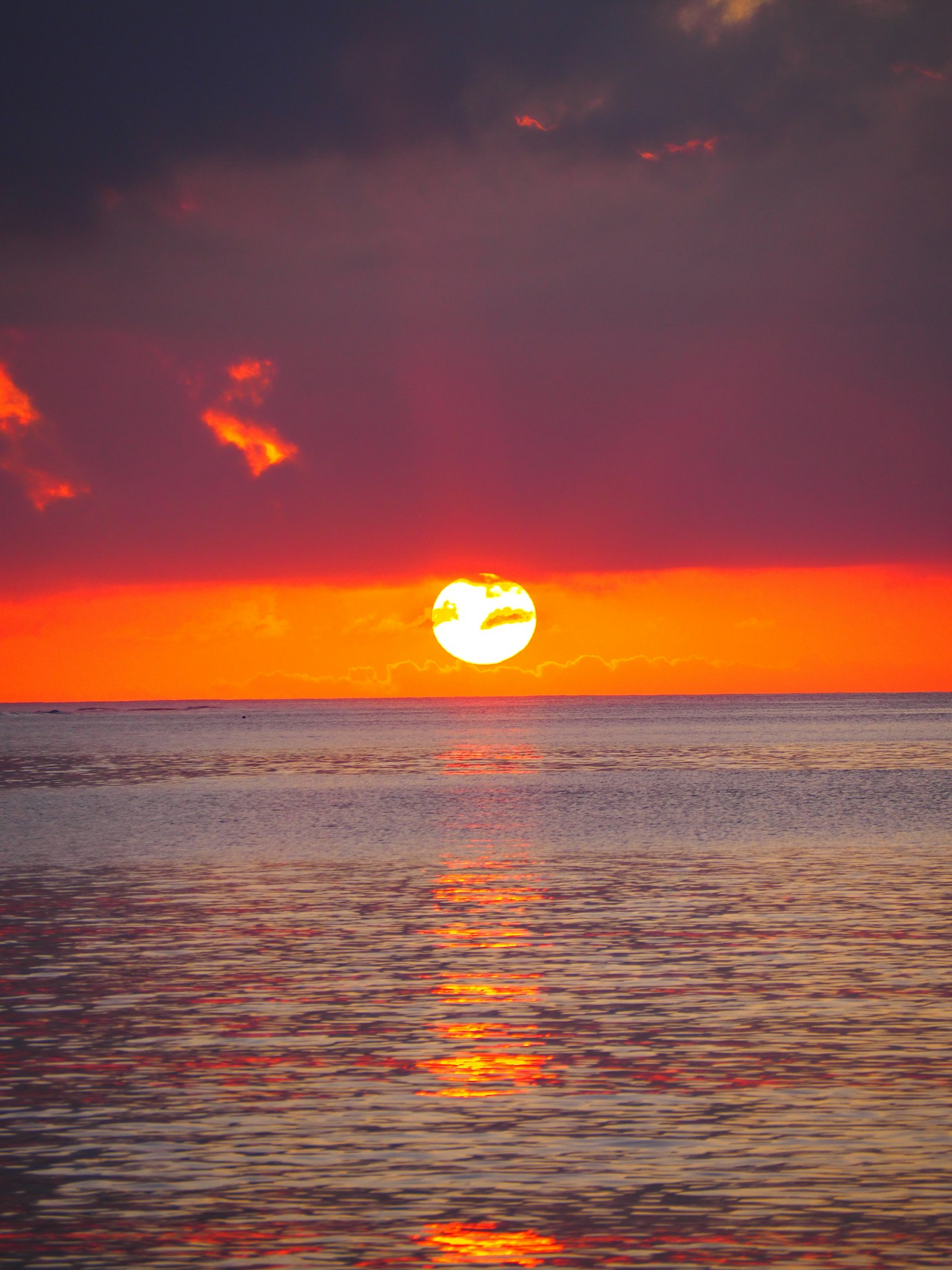 Coucher de soleil spectaculaire sur l'océan avec un ciel orange et rouge