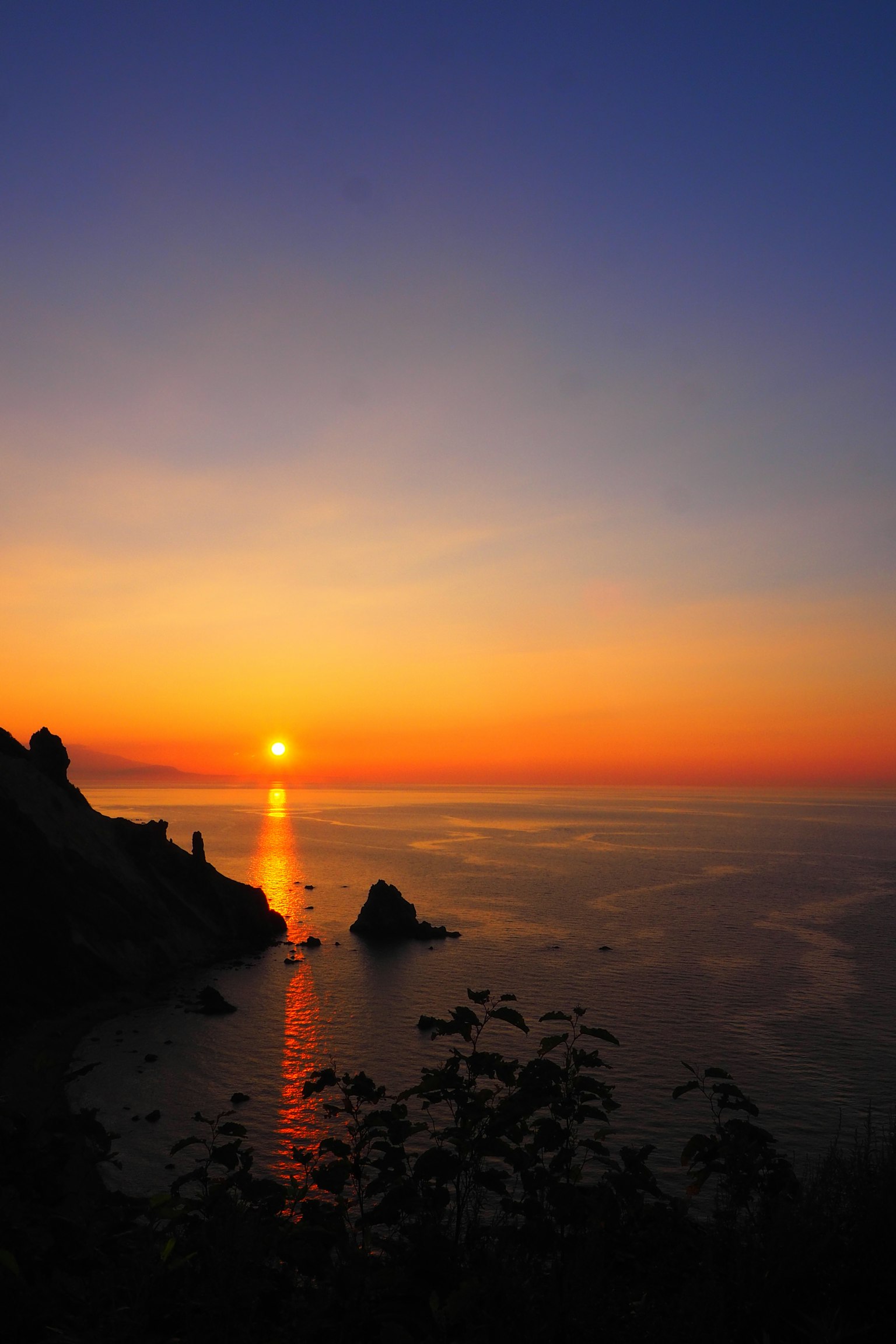 Bellissimo tramonto sul mare con il sole che tramonta all'orizzonte e un cielo blu