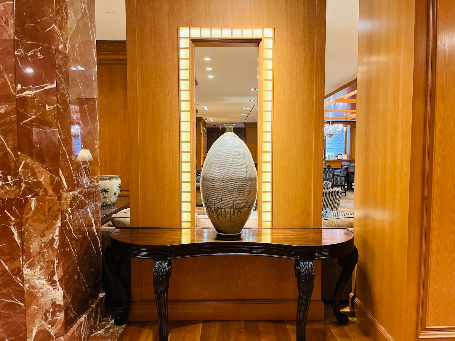 Una grande scultura a forma di uovo su un elegante tavolo in legno circondata da pannelli in legno caldi