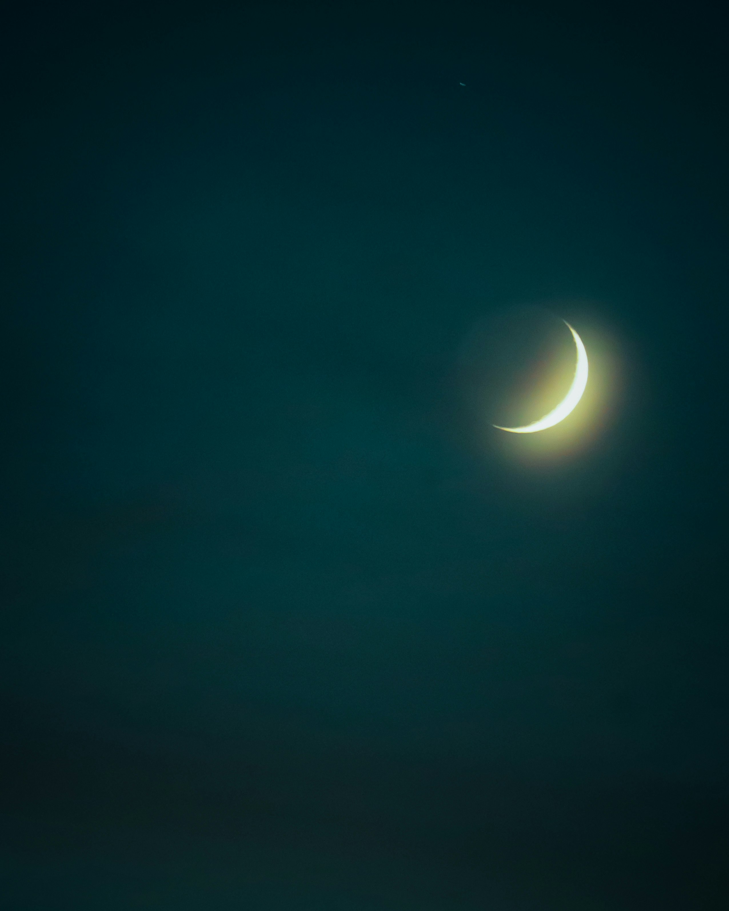 三日月が浮かぶ夜空の光と闇のコントラスト