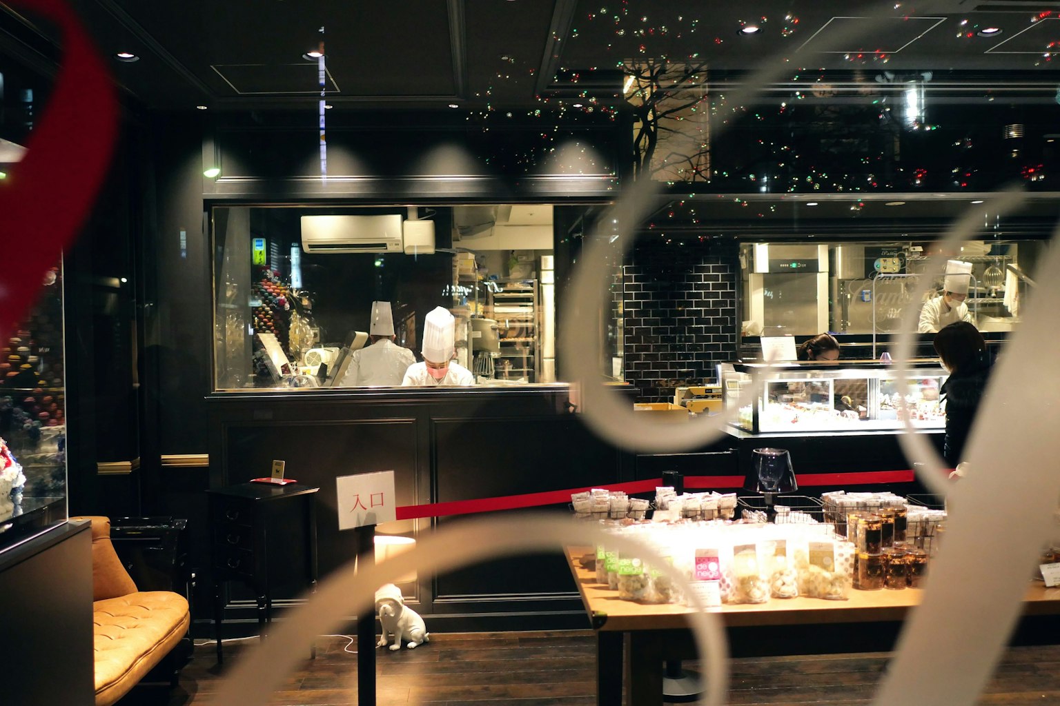 Interno di un caffè moderno che mostra chef che preparano cibo e dessert esposti al bancone