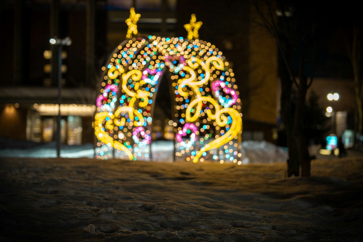 夜间雪中闪烁的彩色灯光拱门