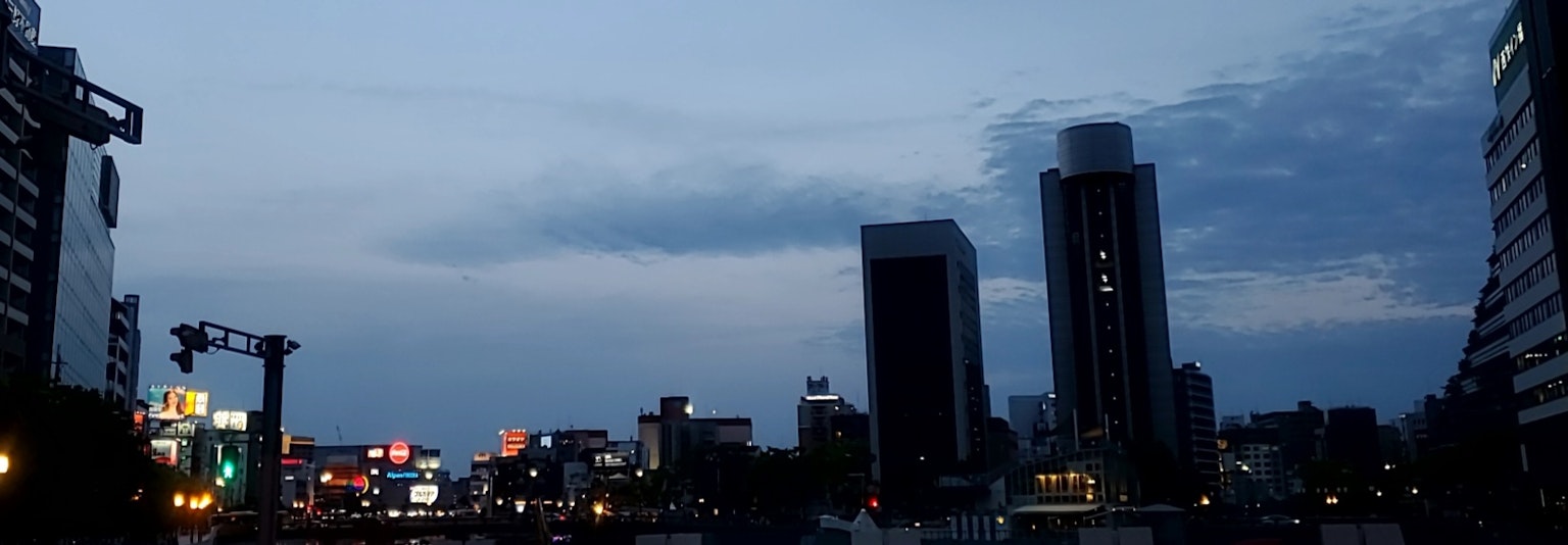 Cảnh quan thành phố ban đêm với biển quảng cáo sáng và tòa nhà chọc trời