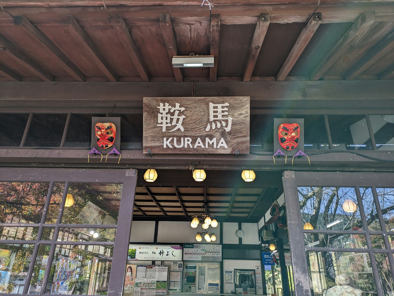 Wooden building sign displaying the word 'Kurama' with traditional Japanese decorations