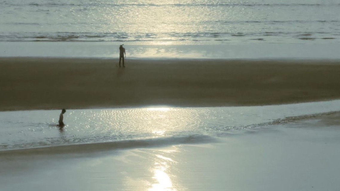 sunset beach with a lone figure on the shoreline