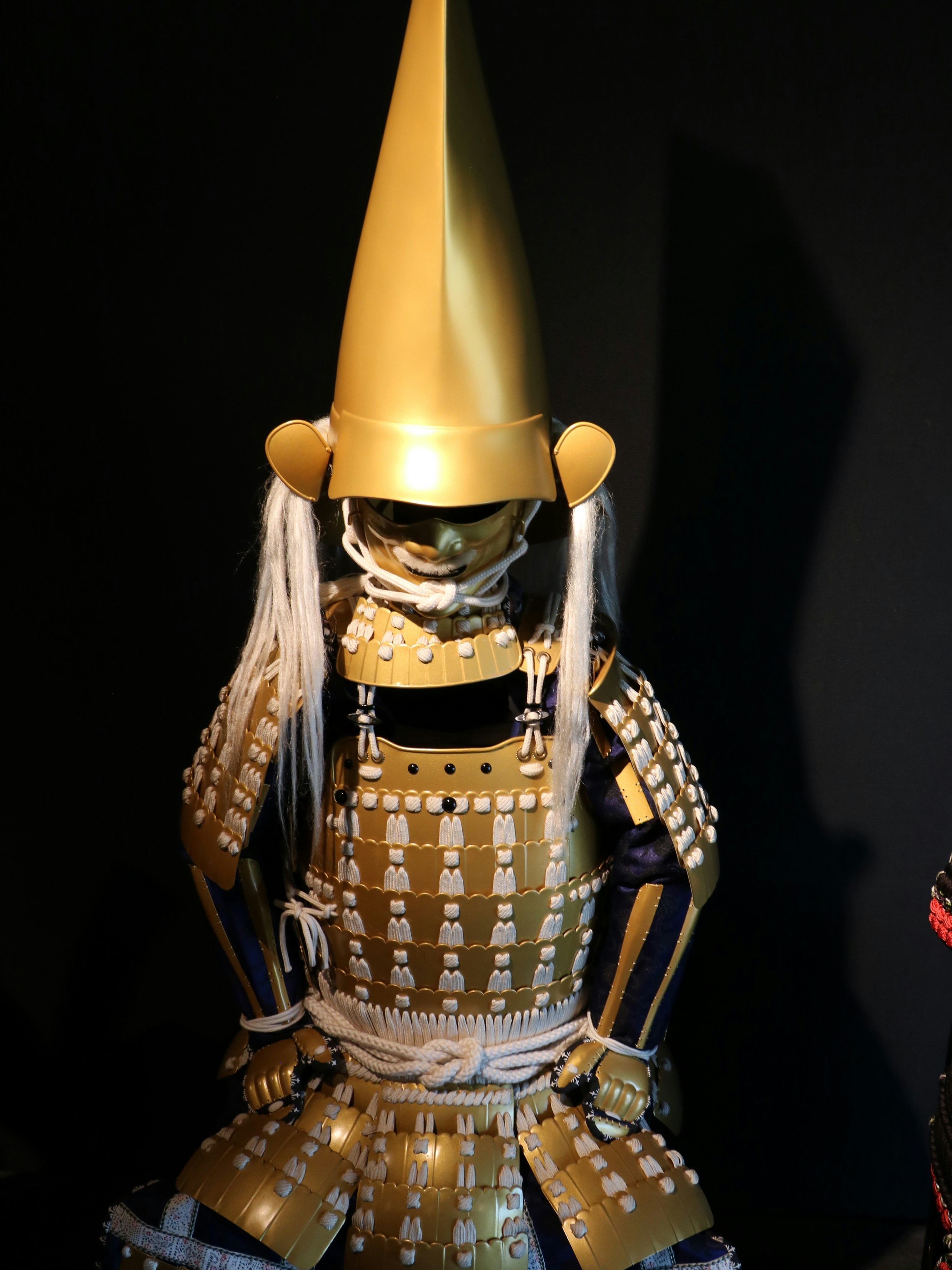 黒背景の金色の兜をかぶった鎧の人形