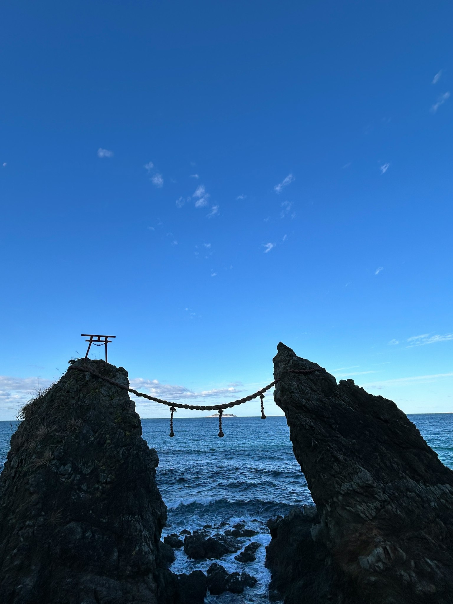 Pont suspendu reliant deux falaises rocheuses au-dessus de la mer