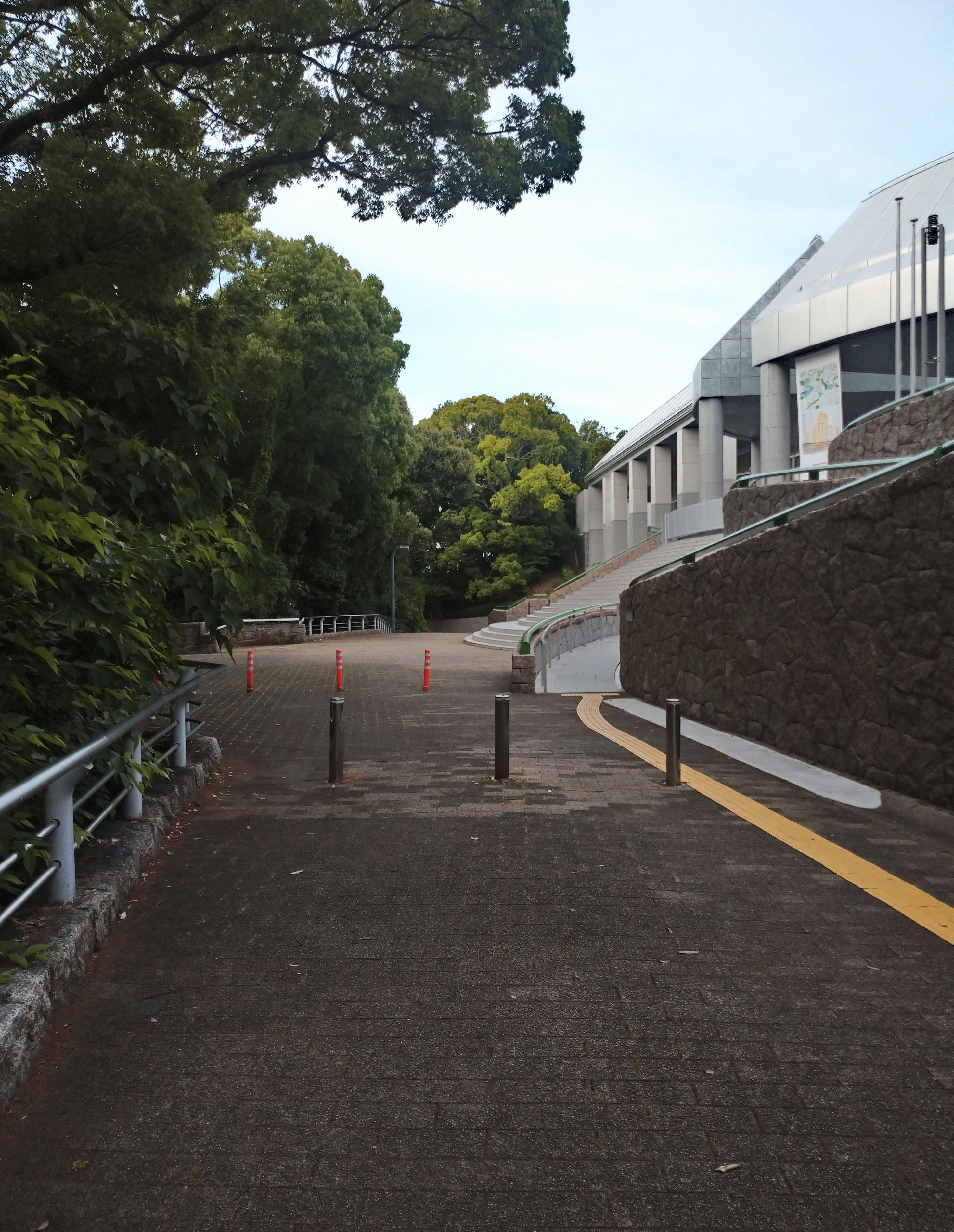 木々に囲まれた遊歩道と緩やかなスロープのある通路