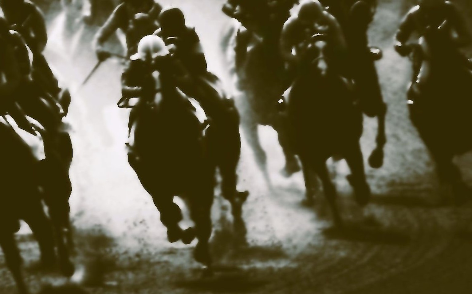 Black and white image of horses and jockeys racing with dynamic movement