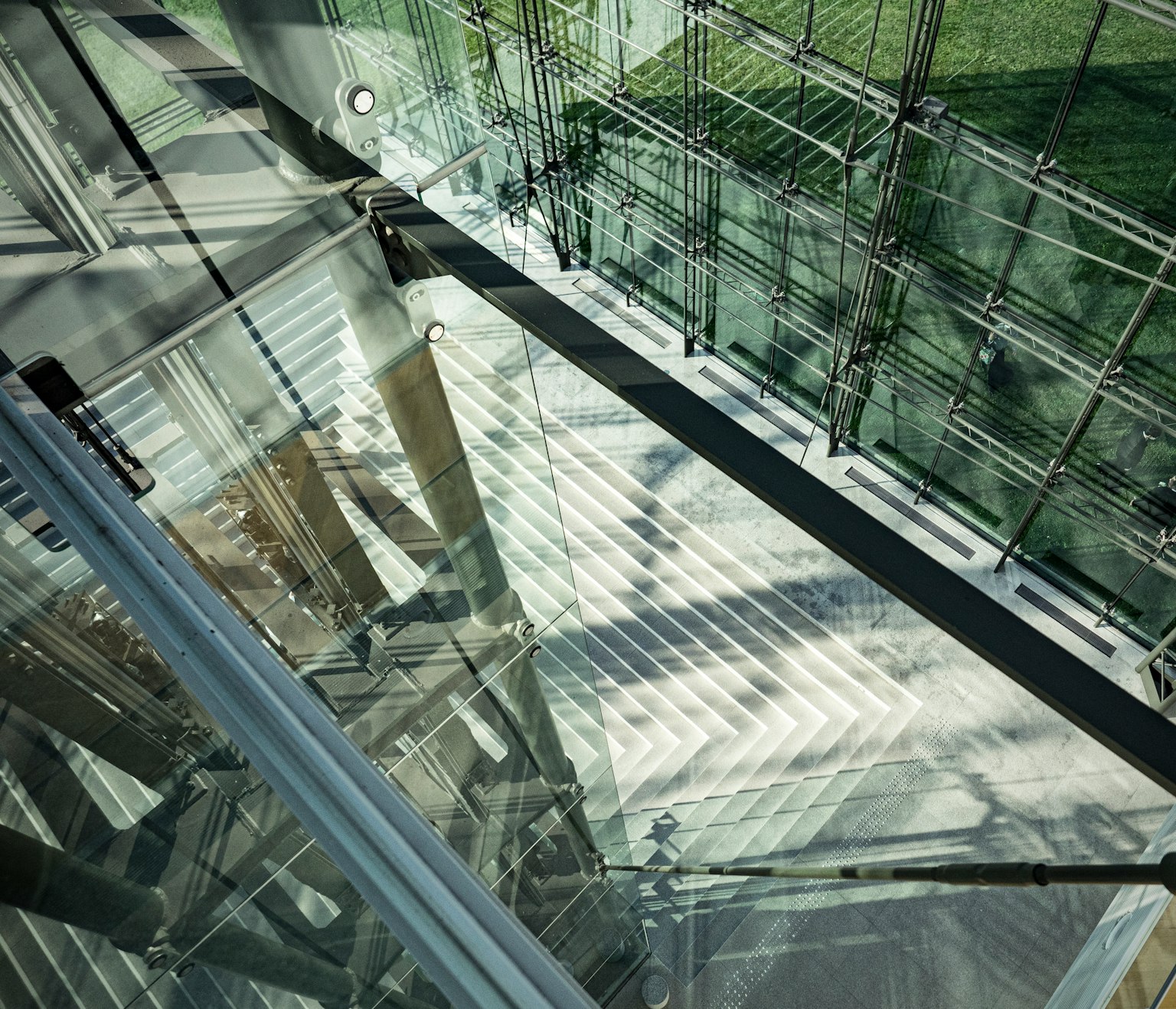 A top-down view of a glass structure showcasing patterns of light and shadow