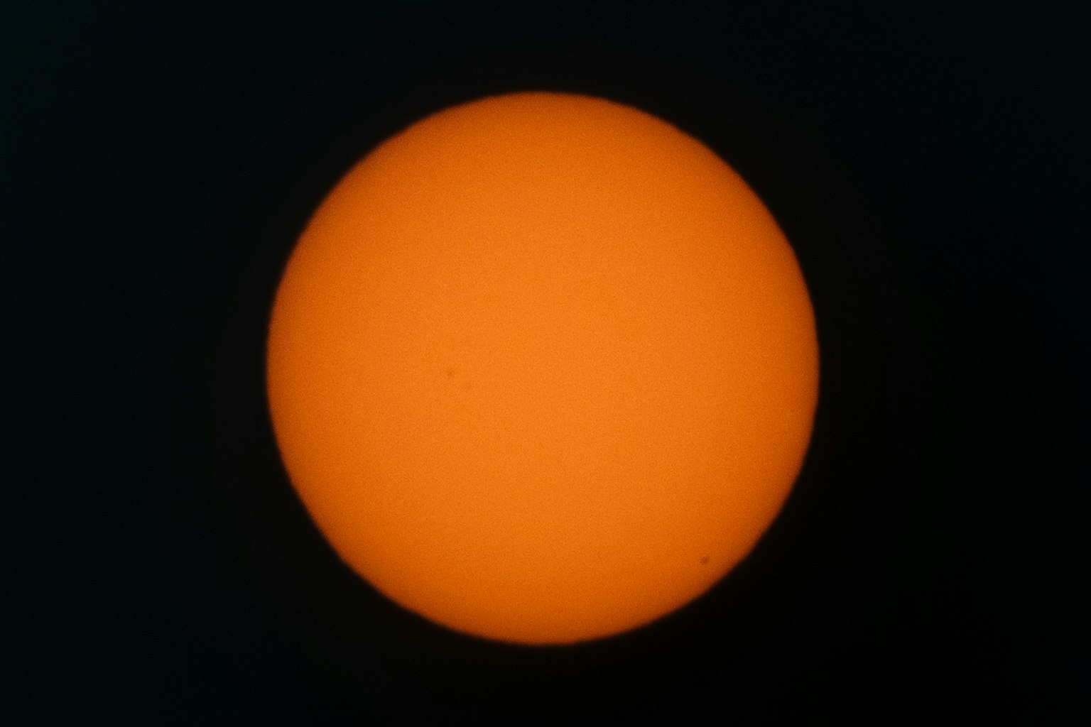 Un sol naranja brillante contra un fondo oscuro