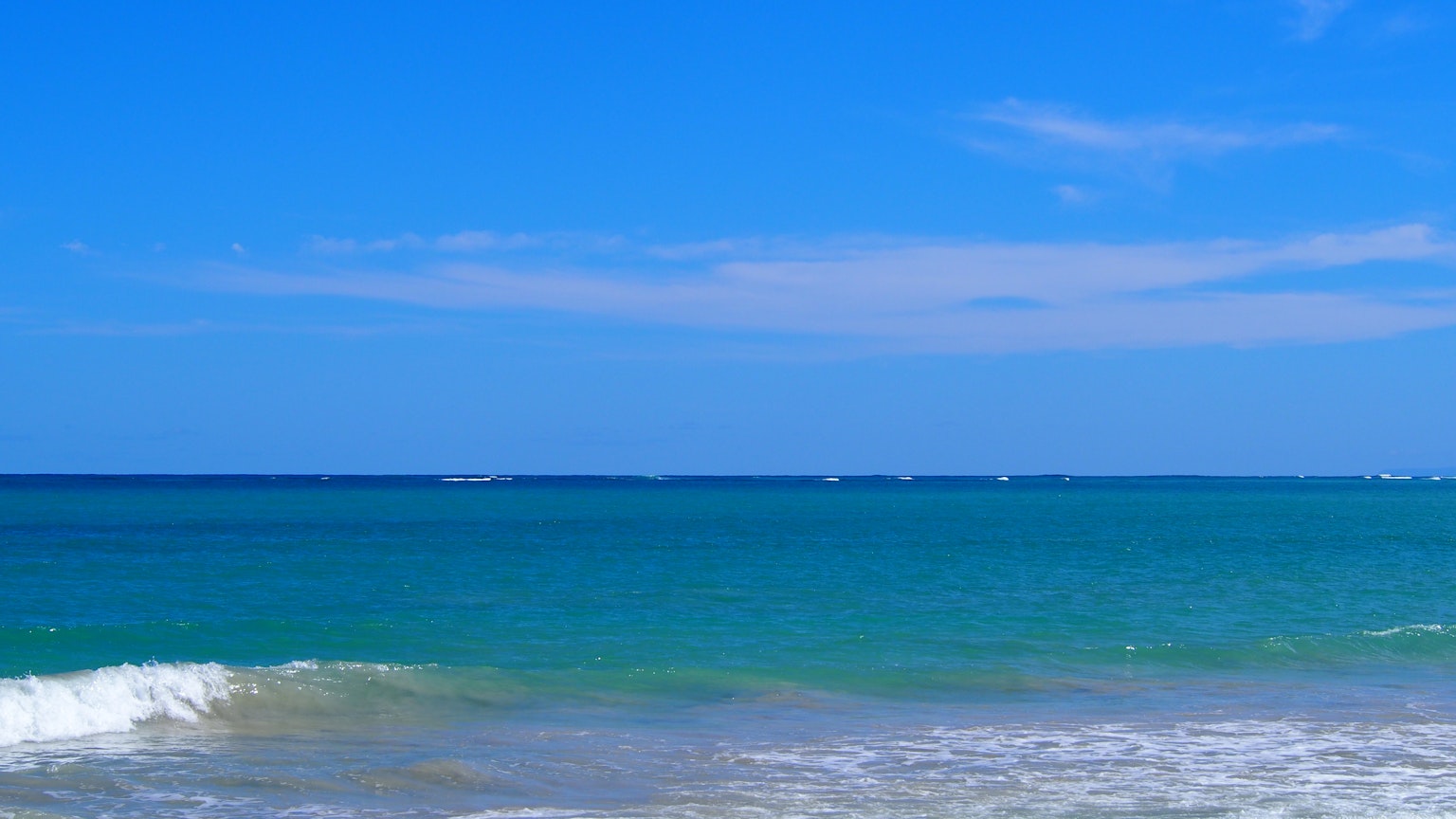Pemandangan lautan dan langit biru ombak menghantam pantai