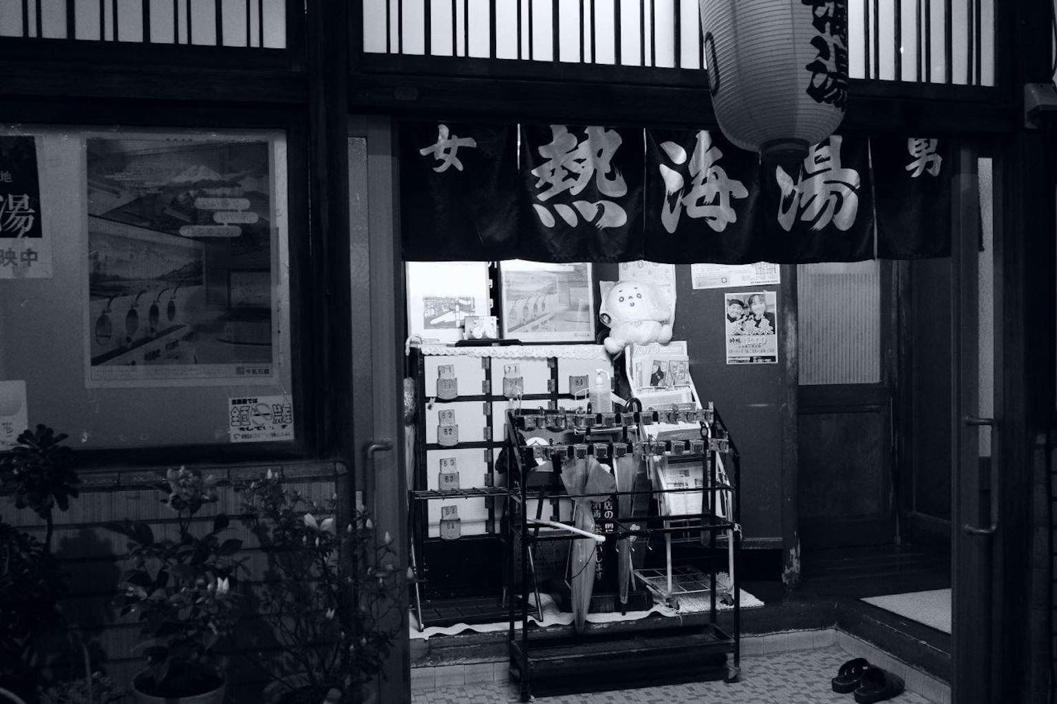 Foto en blanco y negro de la entrada de un manantial con un letrero y una estantería de exhibición