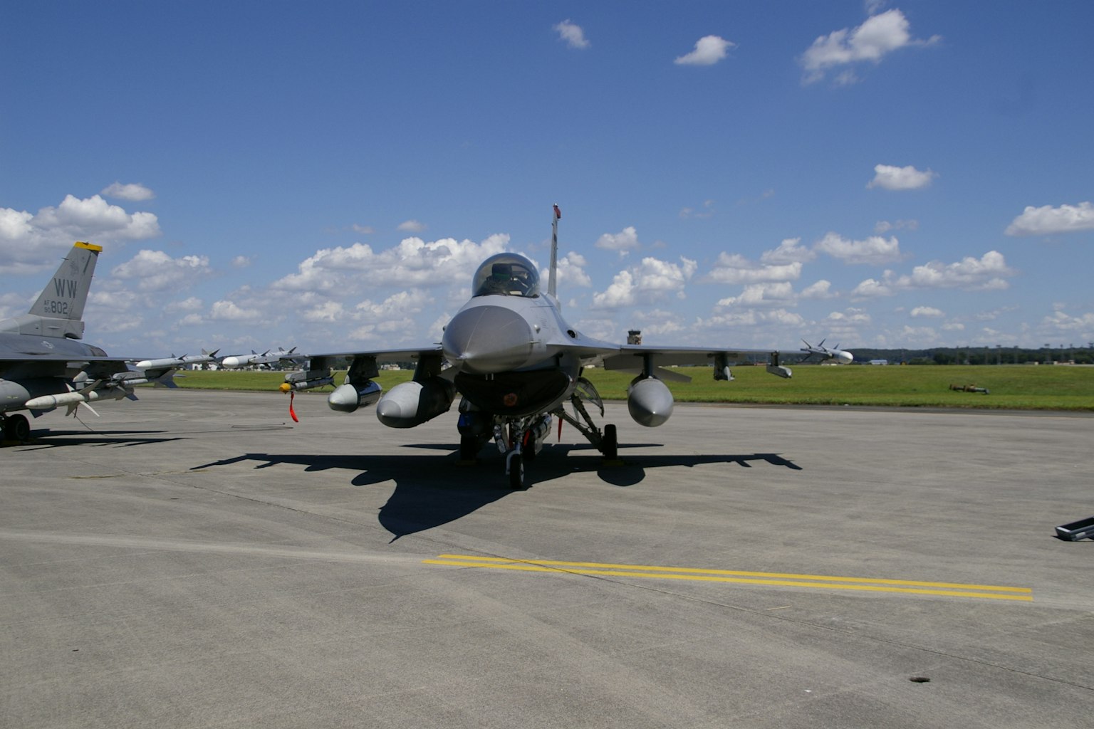 Front view of a fighter jet on an airport runway