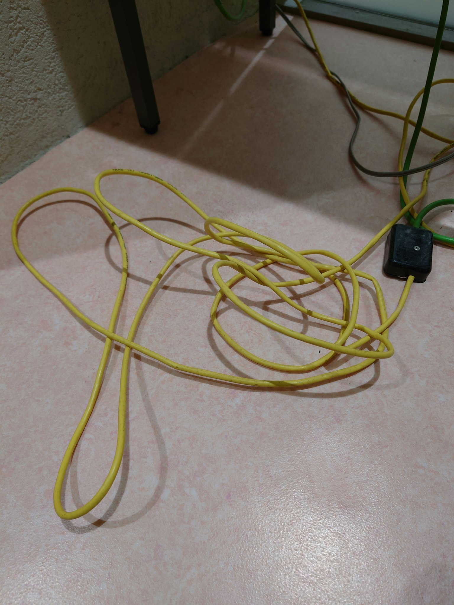 Kabel listrik kuning yang terjerat di lantai