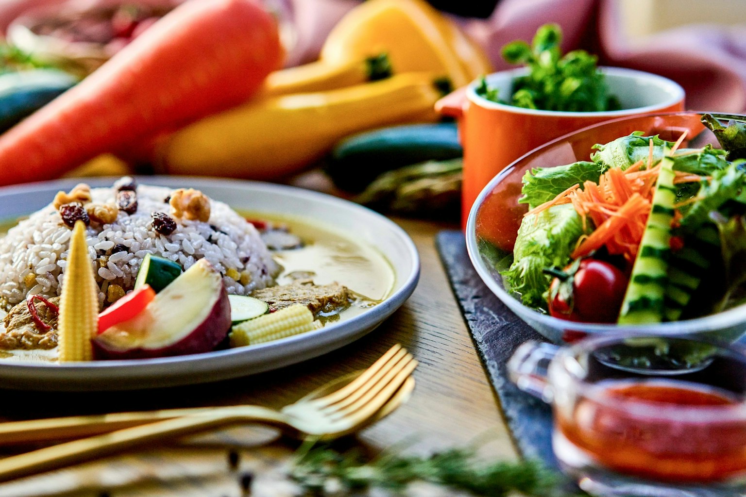 Una comida bellamente presentada con verduras coloridas y ensalada