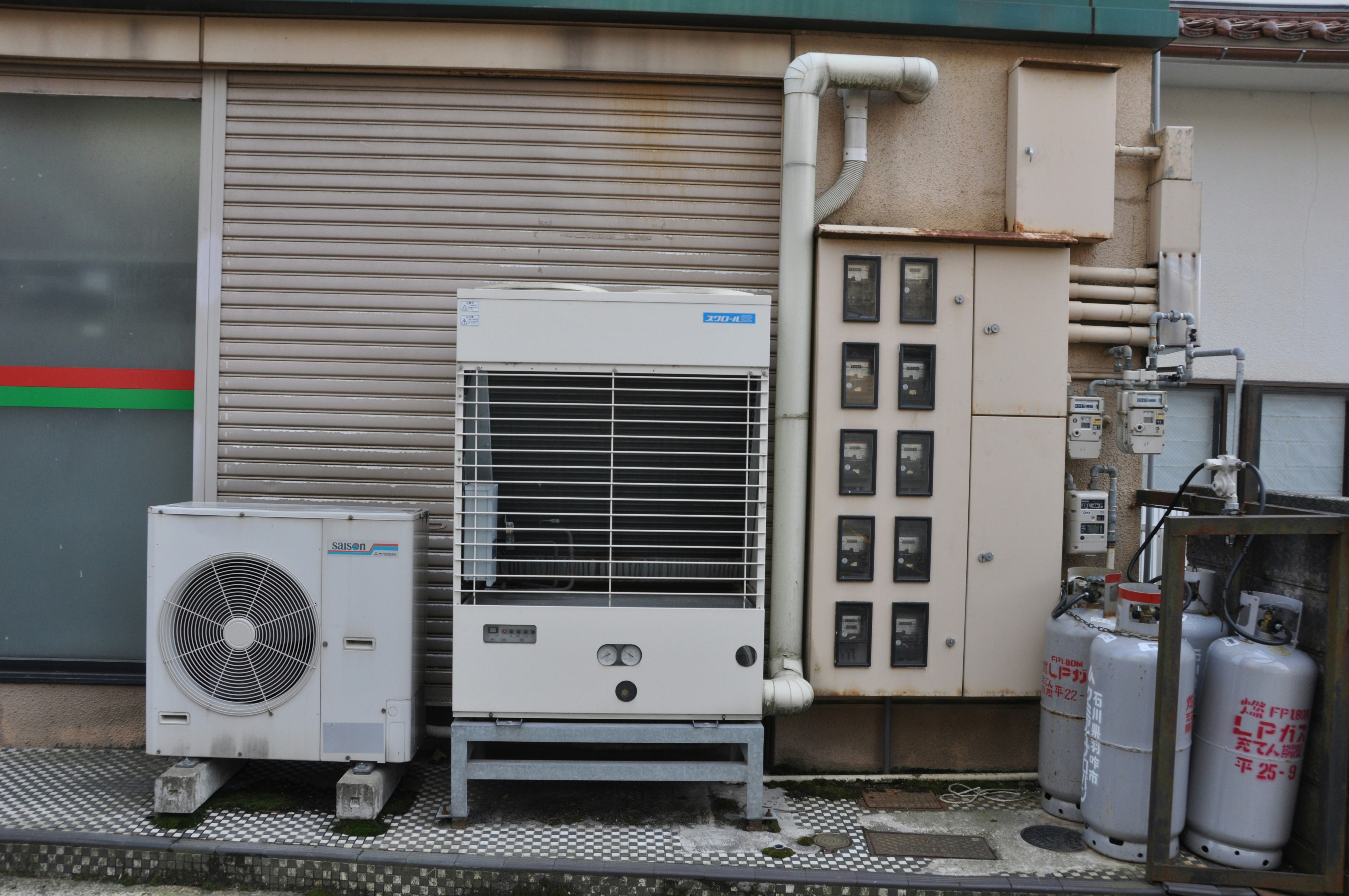 建築外牆旁並排的冷氣室外機與管道