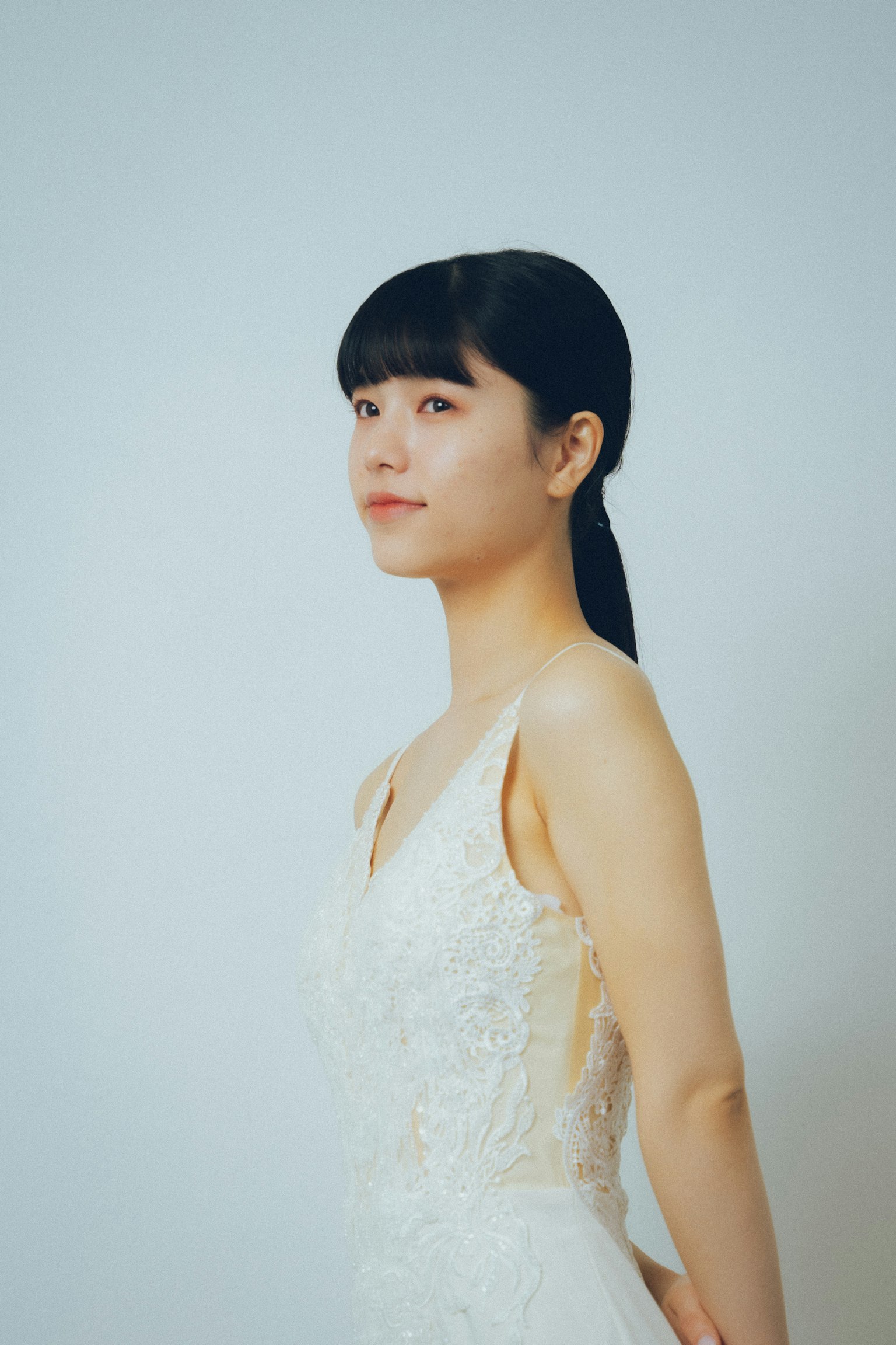Portrait of a woman in a white dress looking sideways
