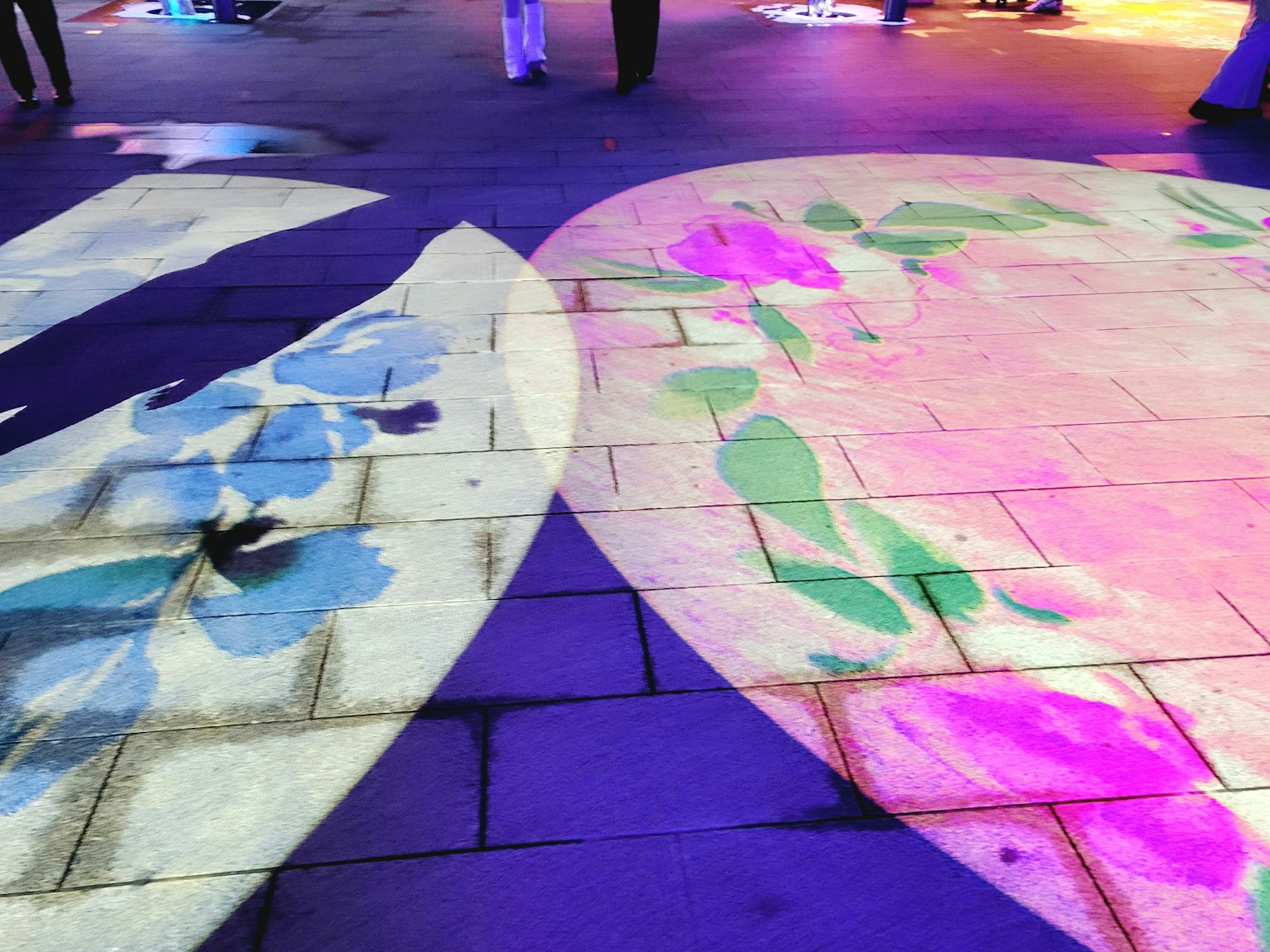 Colorful floral patterns projected on the ground with vibrant lighting