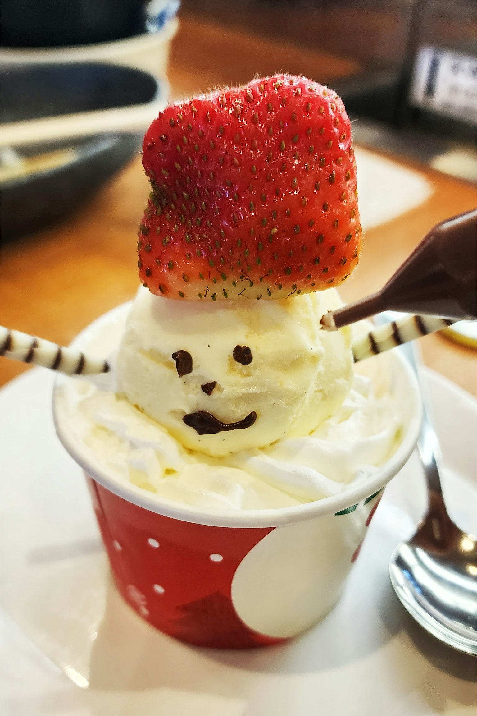Cangkir es krim berbentuk manusia salju dengan stroberi di atasnya