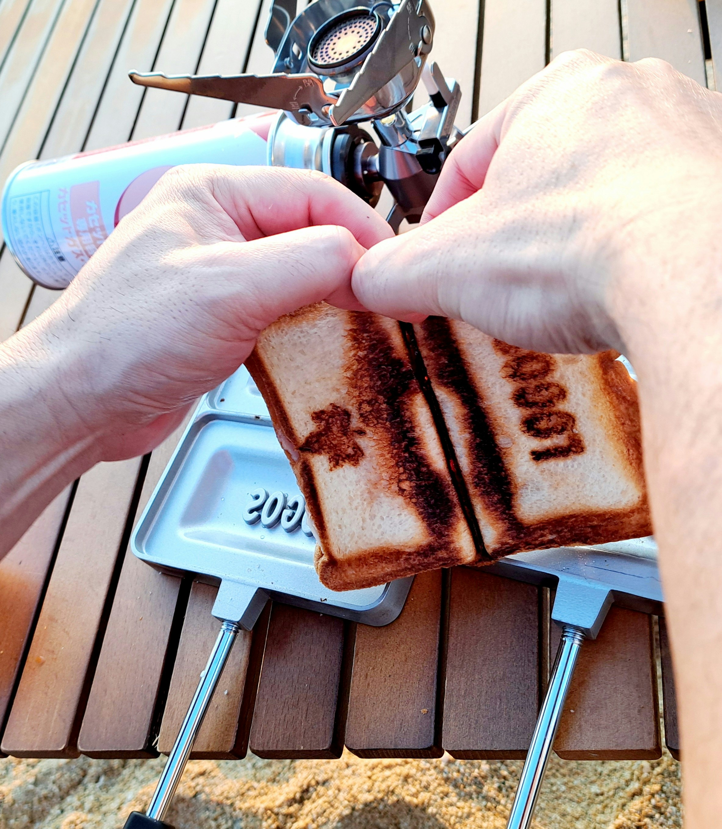 Manos preparando hot sandwiches con marcas de parrilla por la mañana