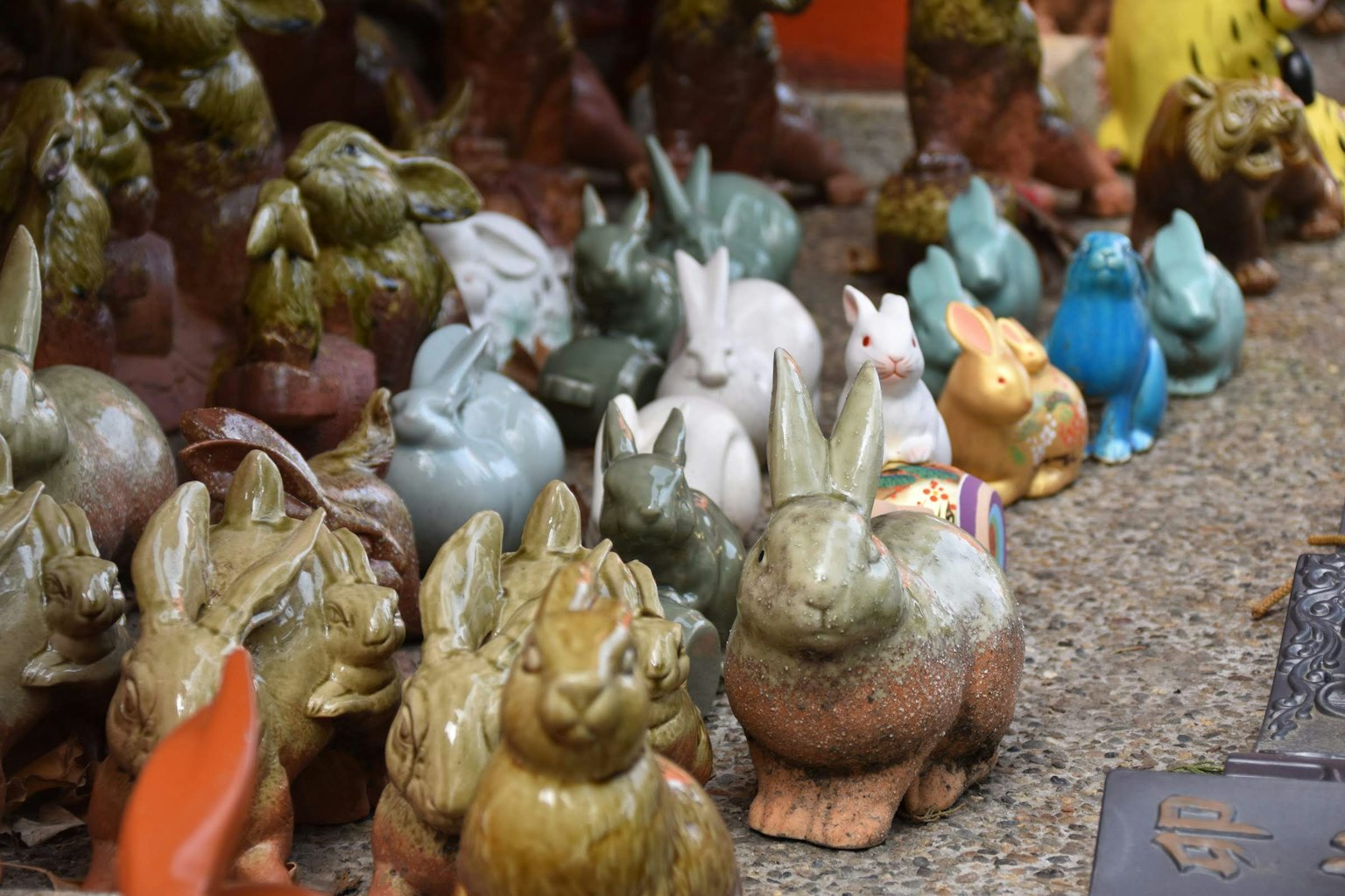 Una variedad de figuras de conejos de cerámica coloridos alineados
