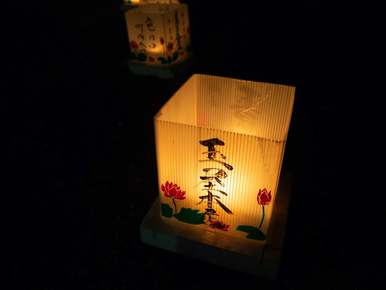 Japanese lantern glowing in the dark featuring bamboo craftsmanship and floral designs