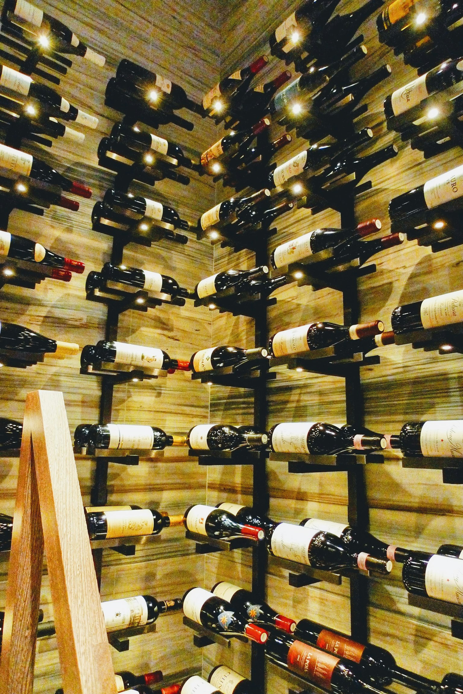 Interior of a wine cellar with numerous wine bottles arranged on a wooden wall